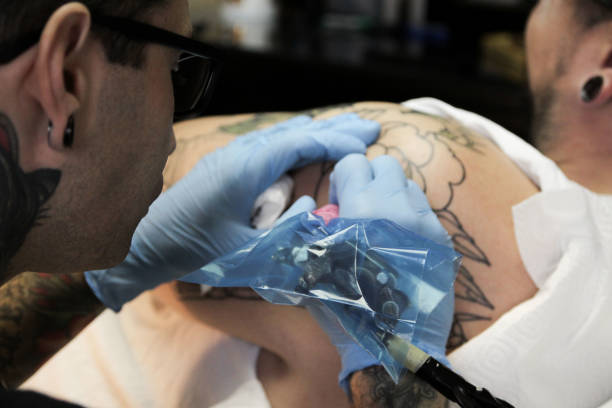 istock Professional tattoo artist doing tattoo in studio 1188016473