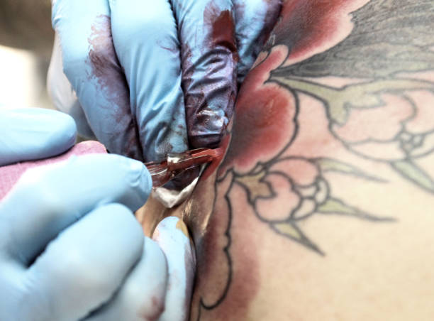 istock Professional tattoo artist doing tattoo in studio 1188016540