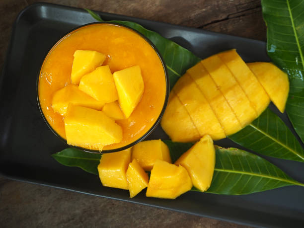 top view mango smoothie in glass with slices of mango fruit on wooden background. taste sweet, tasty, drink for healthy - drink on top of ice food imagens e fotografias de stock