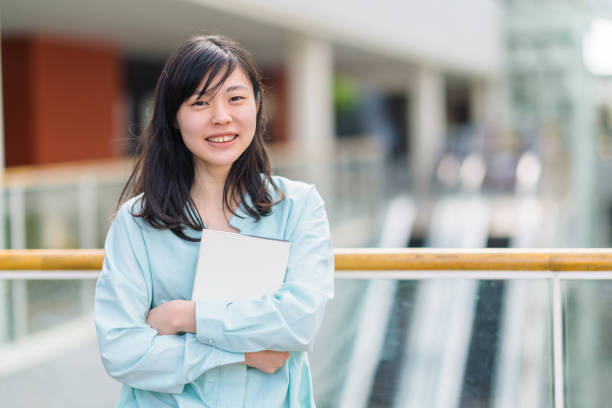 教科書を持ちながらの女子大学生の肖像 - university freshman portrait teenager ストックフォトと画像