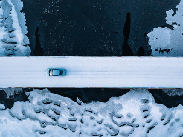 aerial top view of bridge road above frozen river in snow winter finland. - cabin snow finland lapland imagens e fotografias de stock