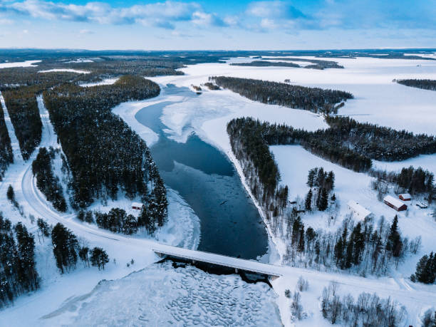 aerial top view of bridge road above frozen river in snow winter finland. - cabin snow finland lapland imagens e fotografias de stock