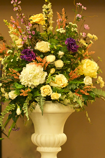 Large bouquet of vibrant coloured flowers in Urn shaped vase