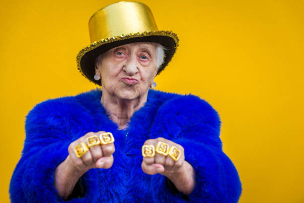 Eccentric senior woman portrait Funny and extravagant senior woman posing on colored background - Youthful old woman in the sixties having fun and partying irony stock pictures, royalty-free photos & images