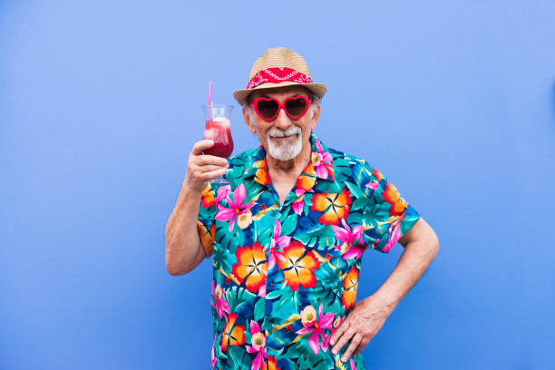 Eccentric senior man portrait Funny and extravagant senior man posing on colored background - Youthful old man in the sixties having fun and partying bizarre fashion stock pictures, royalty-free photos & images
