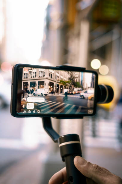 istock Man doing live video with phone with stabilizer  in NY 1188030193
