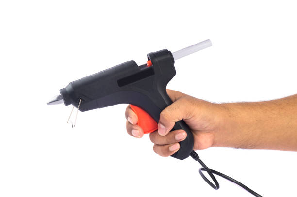 istock Hand holding Electric hot glue gun isolated on white background 1188031700