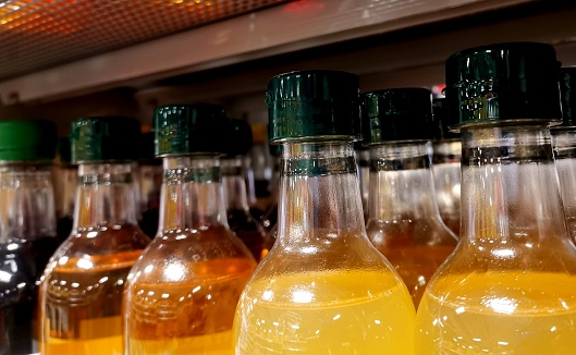 Bottles with colorful liquids in store shelve