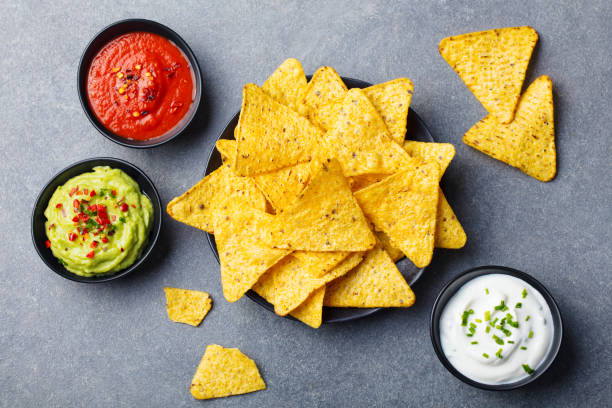 istock Nachos chips in bowl with sauces, dip variety. Grey stone background. Top view. 1188036025