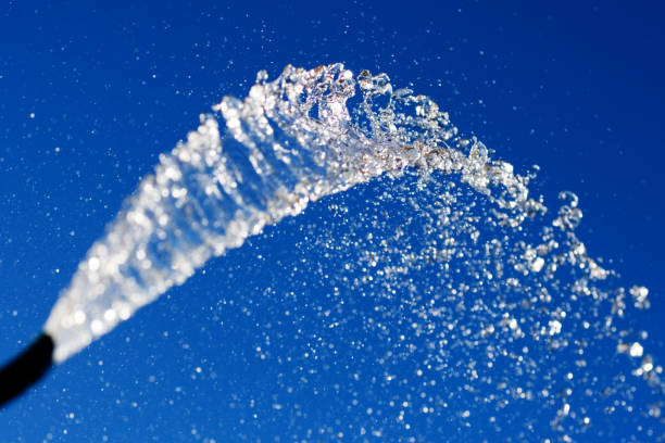istock A stream of water from a hose against a blue sky. 1188039563