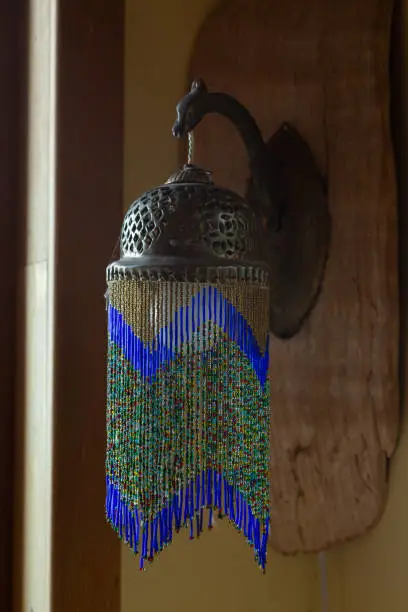 Photo of Beautiful beaded vintage lamp on wall