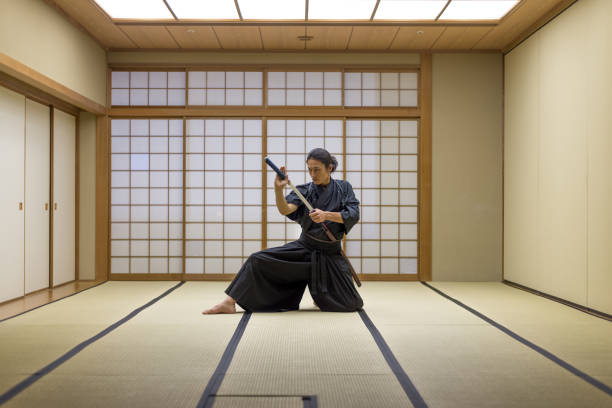 Samurai training in a traditional dojo in Tokyo Japanese martial arts athlete training kendo in a dojo - Samaurai practicing in a gym kendo stock pictures, royalty-free photos & images