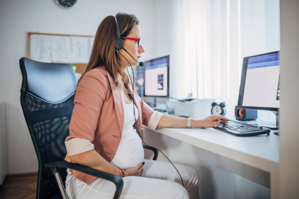istock Pregnant businesswoman using headset at work 1188041725