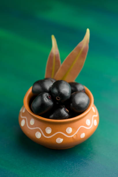 Jambolan plum or jambul or Jamun fruit, Java plum (Syzygium cumini) on textured background. stock photo