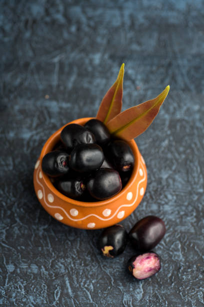 jambolan pflaume oder jambul oder jamun obst, java pflaume (syzygium cumini) mit blatt auf stein strukturierten hintergrund. - plum leaf fruit white stock-fotos und bilder