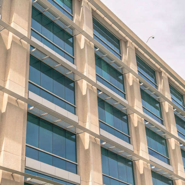 istock Square frame Modern building facade close up with glass windows and sunlit concrete wall 1188045035