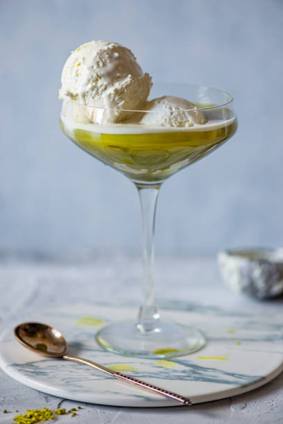 Matcha Affogato in ice cream glass jar, a Japanese and Italian vanilla ice cream cocktail. On grey marble plate. Close up
