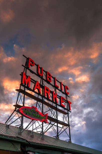 Pike Place Market Seattle, USA - Apr 8, 2018: The famous neon public market sign at Pike Place Market at sunset. elliott bay photos stock pictures, royalty-free photos & images