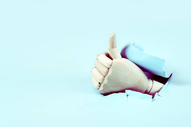 istock Hand through the hole in paper 1188055394