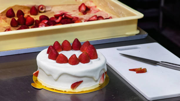 istock A cream cake decorated with strawberries on a kitchen. 1188056802