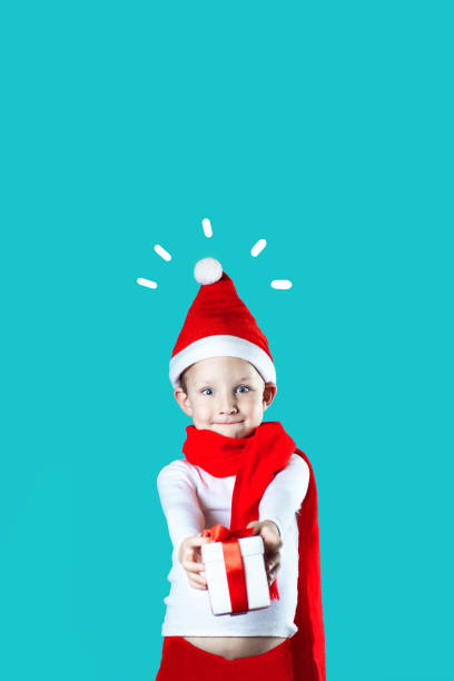 istock little cheerful Santa gives a gift on mint background 1188056924