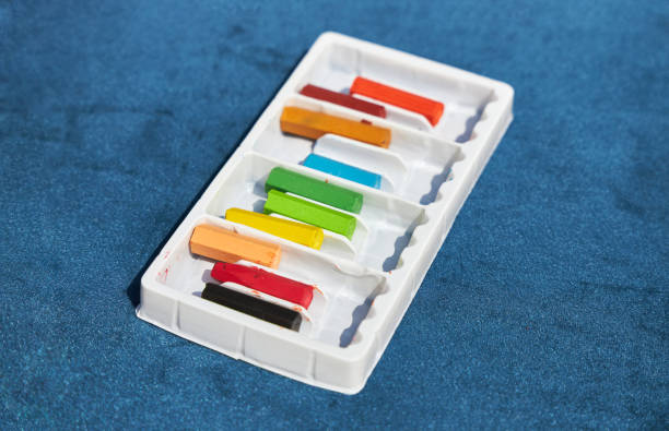 istock Set of colored crayons in a white box lies on a blue surface 1188059176