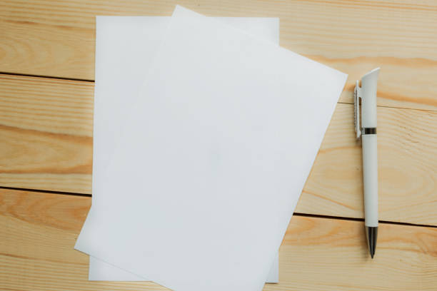 istock White mockup blanks and pen on wooden background. Flat lay, top view, copy space 1188059261