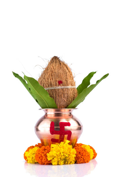 istock Copper Kalash with coconut and mango leaf and pooja thali with diya, kumkum and sweets with floral decoration on a white background. Essential in hindu puja. 1188059300