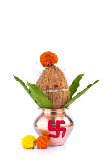istock Copper Kalash with coconut and mango leaf with floral decoration on a white background. Essential in Hindu Puja. 1188060030