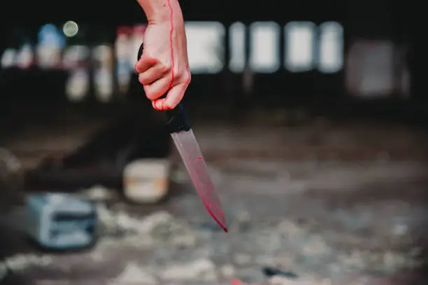 Woman hand holding bloody knife