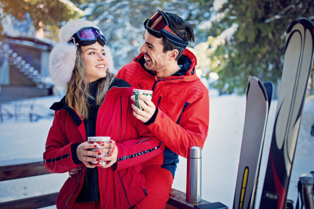 istock Young couple is hugging and drinking hot tea after skiing 1188077696