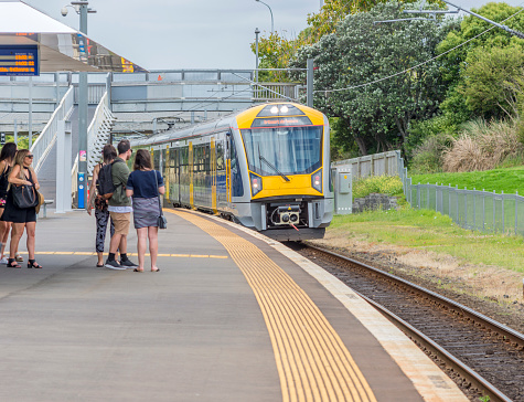 Auckland, New Zealand December 12 2015 Auckland's Orakei railway station on the Eastern Line. People waiting for the train to stop as it approaches