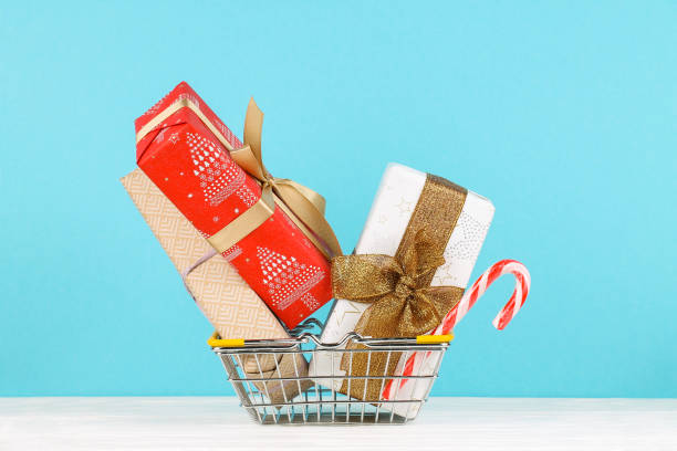 istock Three gift boxes with bows and candy in a shopping basket. 1188085723