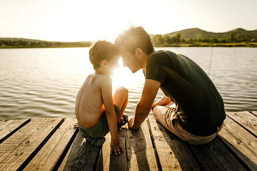 Photo of little boy and his dad, on a lake