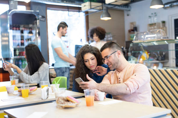 istock Couple sitting in restaurant and looking at phone, talking 1188088868