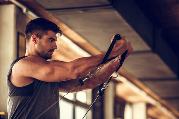 istock Muscular young man working out on cable row machine at the gym 1188088904