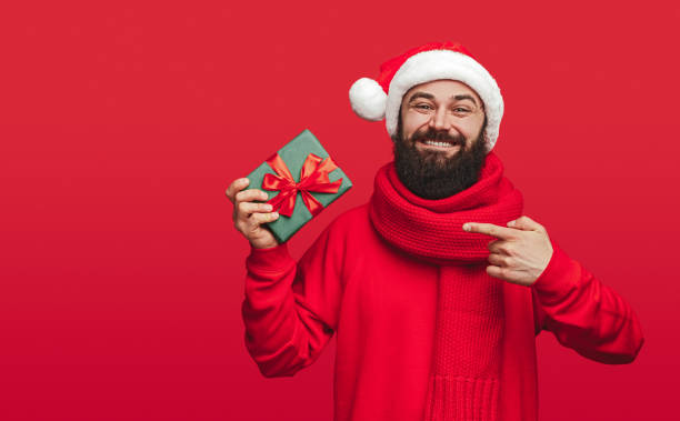 istock Smiling guy showing wrapped Christmas gift 1188089286