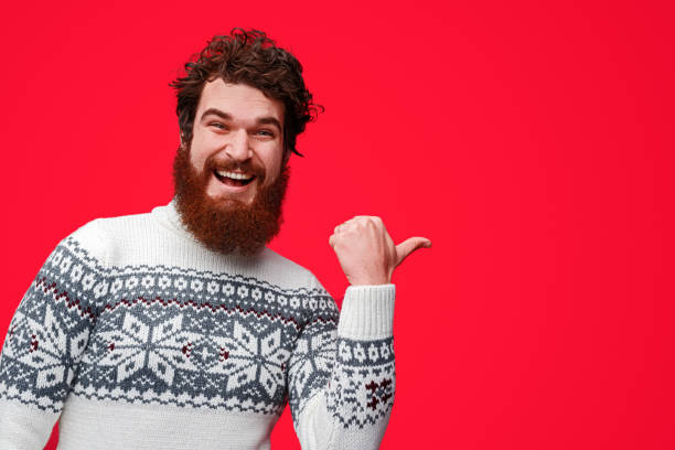 istock Delighted guy in sweater pointing aside 1188089319