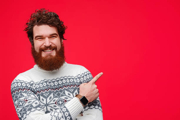 istock Happy guy in sweater pointing aside 1188089320