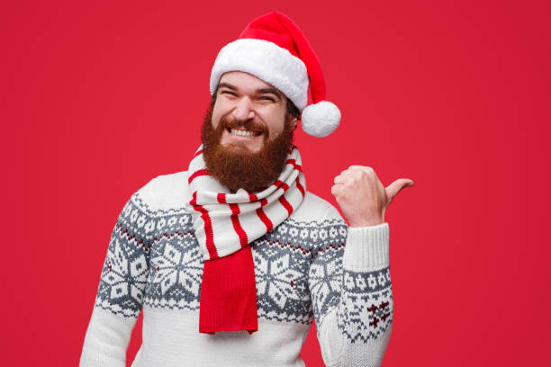 istock Happy male in Santa hat pointing away 1188089330