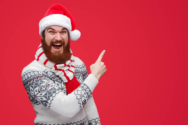 istock Excited man in Santa hat pointing at empty space 1188089336