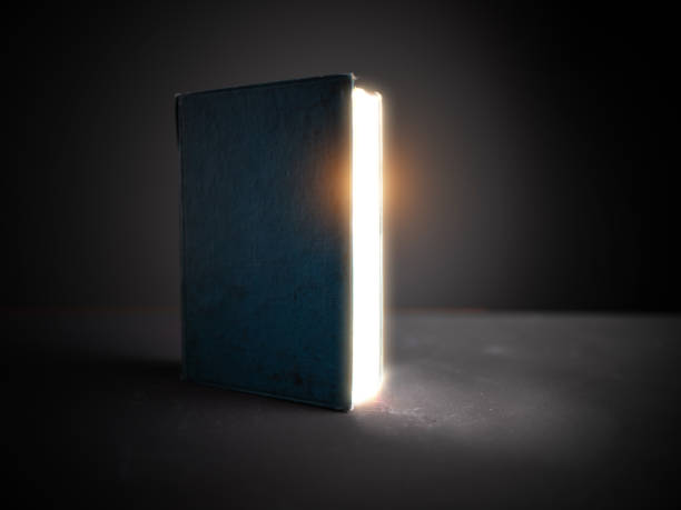 Old open book with magic light and falling on wooden
