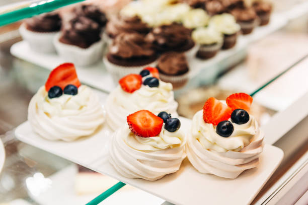 istock Shop window with chocolate cupcakes and meringue dessert at bakery store 1188093317