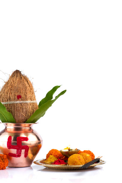 istock Copper Kalash with coconut and mango leaf and pooja thali with diya, kumkum and sweets with floral decoration on a white background. Essential in hindu puja. 1188093538