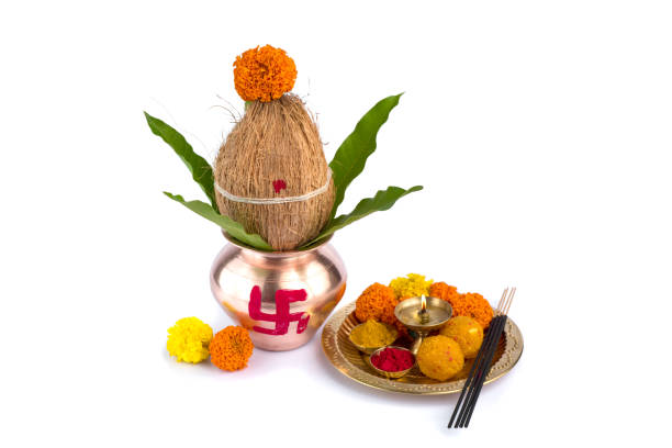istock Copper Kalash with coconut and mango leaf and pooja thali with diya, kumkum and sweets with floral decoration on a white background. Essential in hindu puja. 1188093558