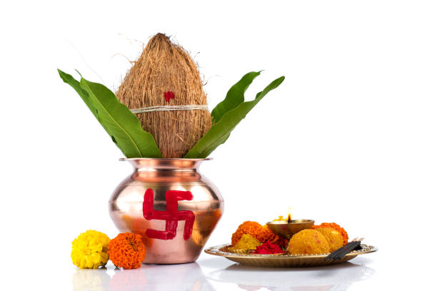 istock Copper Kalash with coconut and mango leaf and pooja thali with diya, kumkum and sweets with floral decoration on a white background. Essential in hindu puja. 1188093591