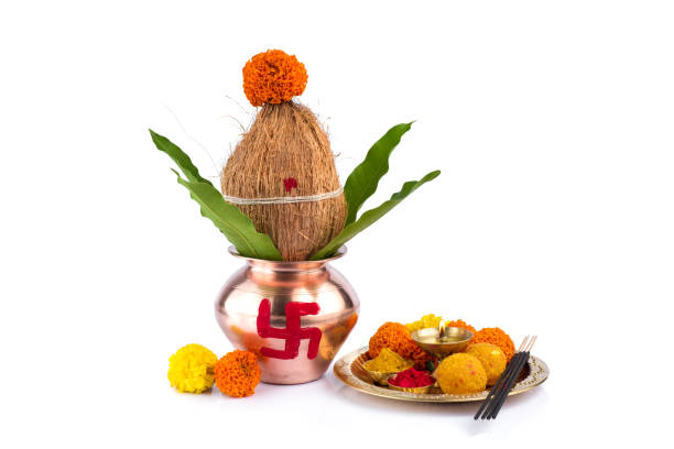 istock Copper Kalash with coconut and mango leaf and pooja thali with diya, kumkum and sweets with floral decoration on a white background. Essential in hindu puja. 1188094155
