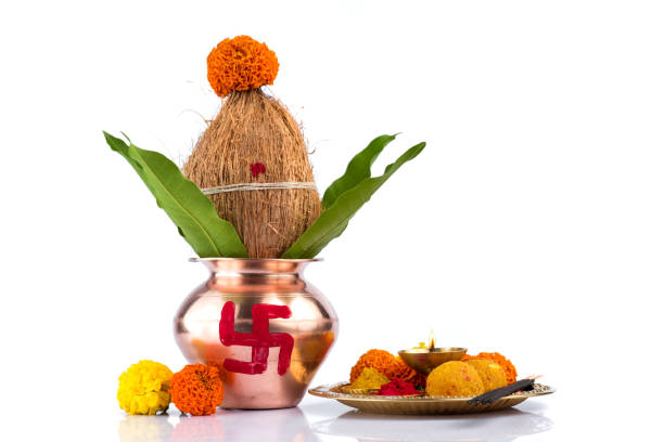istock Copper Kalash with coconut and mango leaf and pooja thali with diya, kumkum and sweets with floral decoration on a white background. Essential in hindu puja. 1188094175
