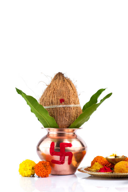 istock Copper Kalash with coconut and mango leaf and pooja thali with diya, kumkum and sweets with floral decoration on a white background. Essential in hindu puja. 1188094331