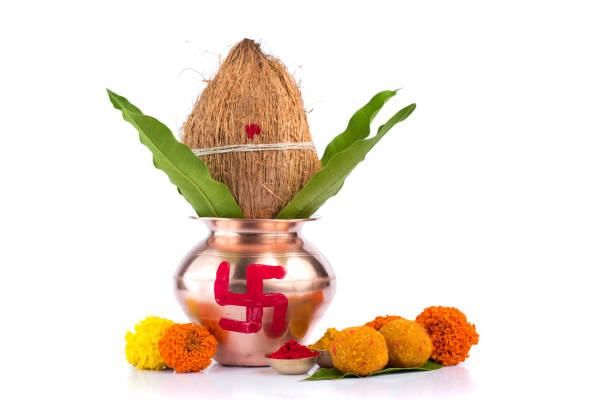 istock Copper Kalash with coconut, mango leaf, Haldi, kumkum and sweets with marigold flower decoration on a white background. Essential in Hindu puja. 1188094376